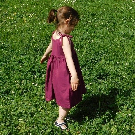 Spokojená malá zákaznice v dívčích šatech Jožánek